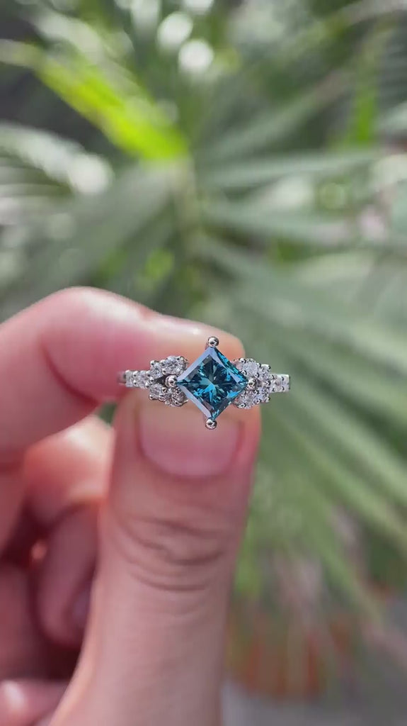 Video showcasing princess cut fancy vivid blue lab grown diamond cluster engagement ring with moissanite accents in 14K white gold