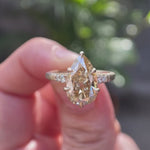 Pear cut light champagne moissanite ring shown from multiple angles in 10K yellow gold