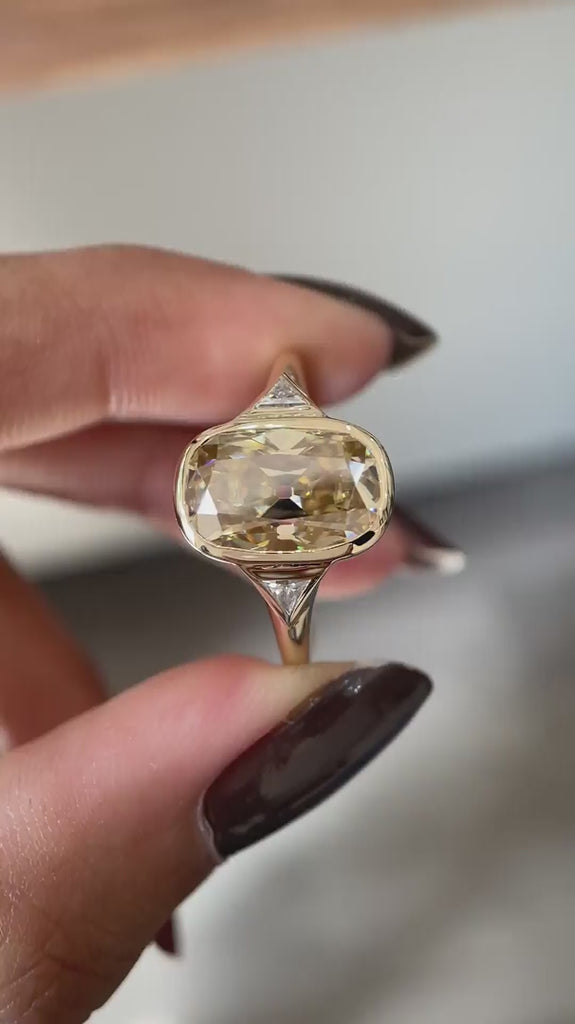 Close rotating view elongated champagne cushion moissanite three stone ring