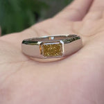 Close detail view highlighting radiant yellow diamond signet setting.