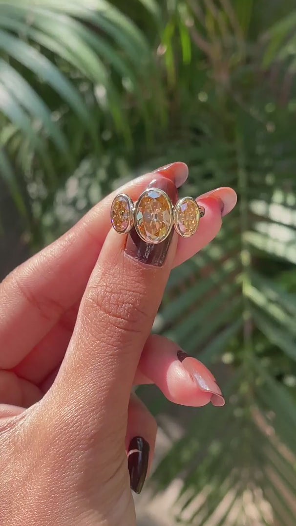 Close rotating view highlighting elongated oval champagne moissanite stones.