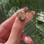 Close rotating view highlighting elongated oval champagne moissanite stones.