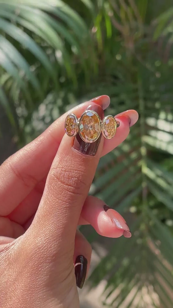 Close rotating view highlighting elongated oval champagne moissanite stones.