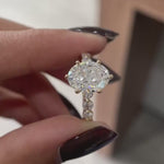 Close rotating view oval lab diamond ring with round side stones in yellow gold