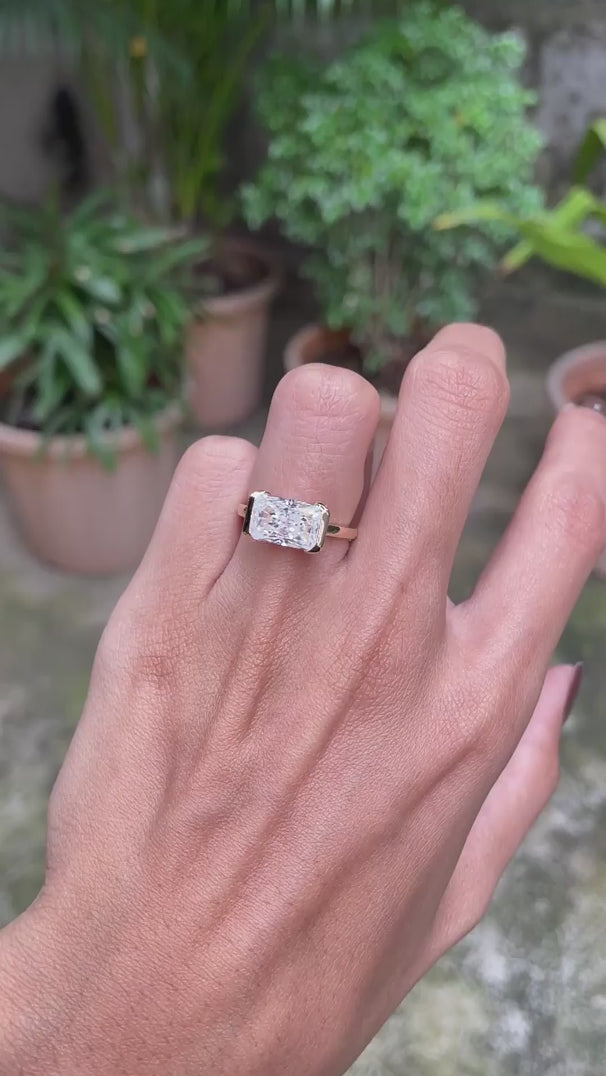 14k yellow gold east west radiant cut moissanite engagement ring featuring modern floating half bezel design