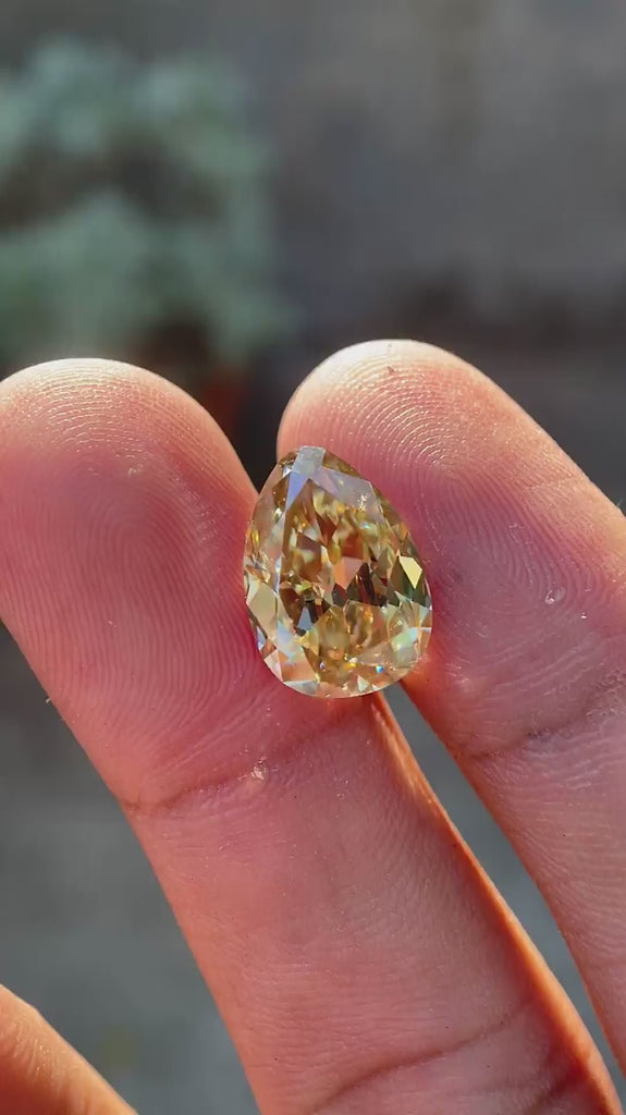 Pear Old Mine Cut Yellowish Moissanite showing brilliance and facet movement in natural light
